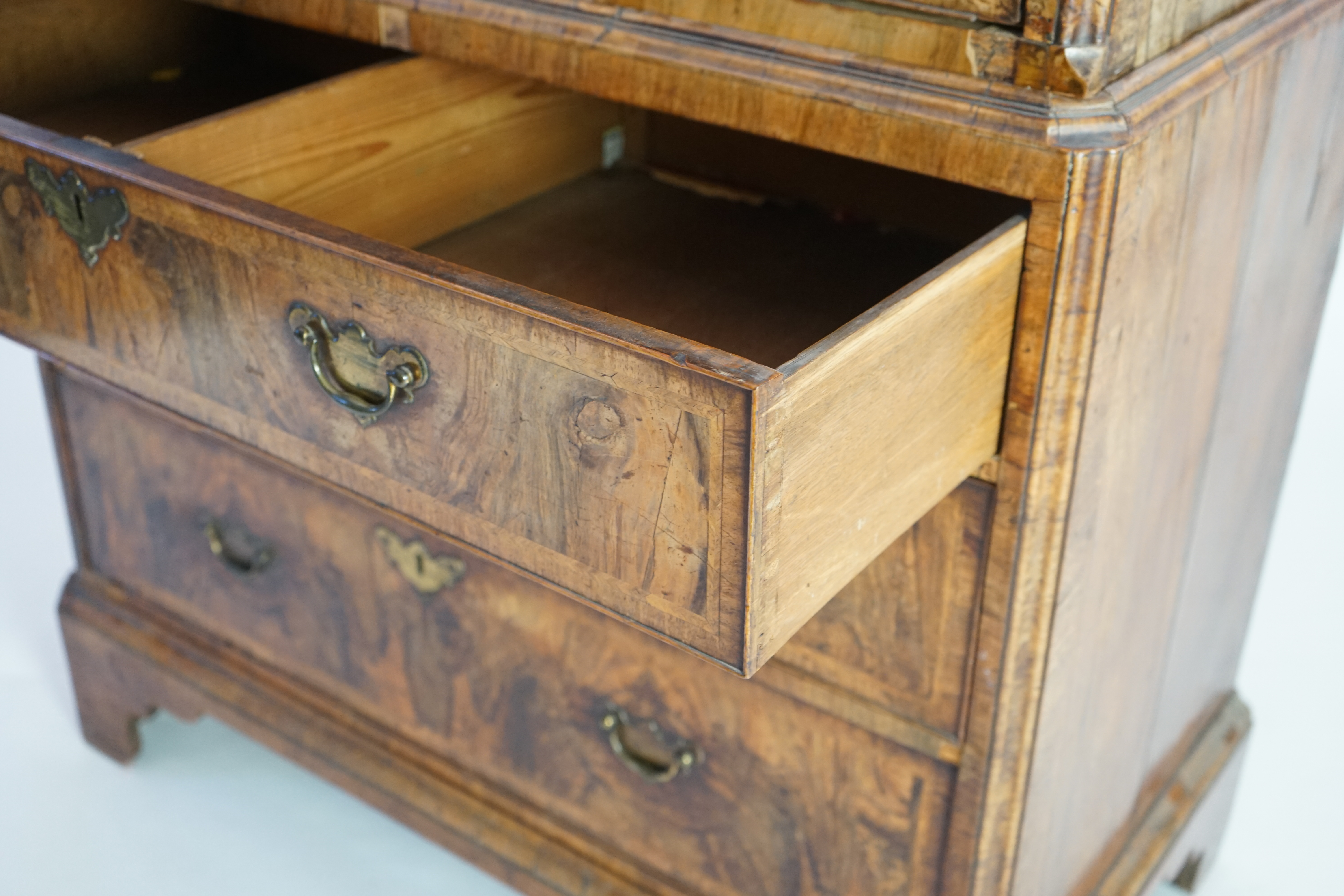 A George II feather banded walnut chest on chest